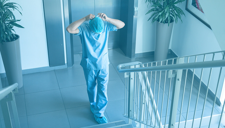 enfermero subiendo unas escaleras después de atender a una víctima por accidente de tráfico en un hospital público